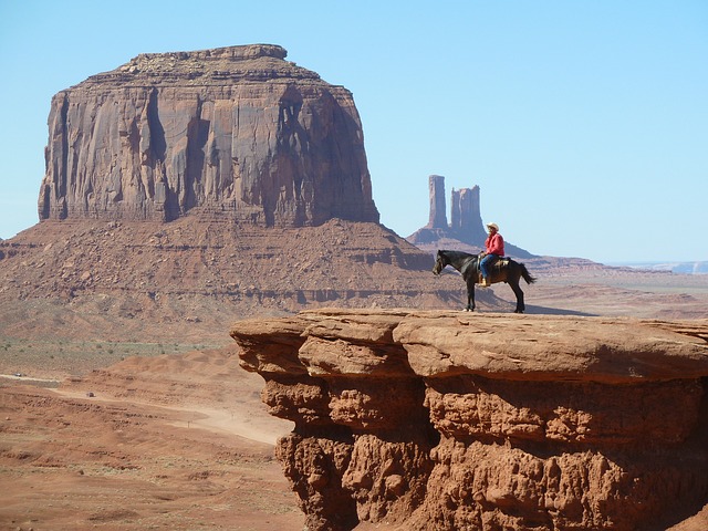 Cowboy auf einem Pferd mitten im Monument Valley.